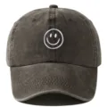 Casquette de baseball noire délavée avec un joli visage souriant brodé blanc sur le devant. - Réglable / Café
