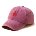 Close-up detail of the embroidered maple leaf on a vintage washed red baseball cap fabric. - Adjustable / Burgundy