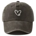 Detalle en primer plano de gorra de béisbol gris lavada con estampado de corazón y huella. - Ajustable / Café