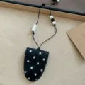 Nahaufnahme der schwarz-weißen Pünktchen Sonnenbrillen-Clip-Halskette mit Kordel und Perlen. - Punktierung Perlen Stil (HN13410) / Schwarz