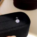 Detailed shot of a dazzling cubic zirconia stud earring on a black velvet display stand. - Pair / Silver-Light Pink-7mm