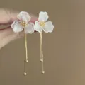 Close-up detail view of elegant white flower long tassel earrings with shimmering gold chains. - Gold-White Flower (29#)