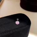 Detailed view of a stylish pink cubic zirconia screw-back stud earring on black velvet display. - Pair / Silver-Pink-5mm