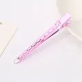Close-up of a pink metal duckbill hair clip with cutout design, perfect for sectioning hair. - Pink
