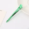 Green metallic duckbill hair clip with cutout design for hair styling and sectioning. - Green