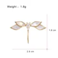 Detailed view of the elegant dragonfly brooch featuring mother-of-pearl wings and sparkling stone. - G107-H