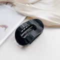 Detailed close-up of a stylish black oval hair claw clip, perfect for elegant buns and updos. - Black