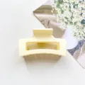 Close-up detailopname van de lichtgele vierkante matte haarklem, modern en stijlvol. - Mat Crème