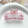 Detail view of a clear square hair claw clip featuring sweet pink bows and red heart prints. - Type B Square Thermal Transfer (8.5cm) / Clear