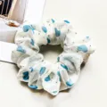 Close-up detail of white chiffon hair scrunchie featuring blue hearts and shimmering rhinestones. - Heart Blue
