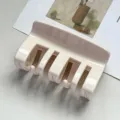 Gedetailleerde close-up van een minimalistische beige acryl haarclip met tandjes. - Kam-Tand Haarklem (89817) / 9.5cm / Huidskleur