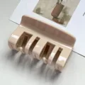 Detail view of a minimalist beige PC hair claw clip, elegant hair accessory for styling. - Light Coffee