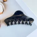 Detail view of black glossy hair claw clip, elegant minimalist design for secure updo styling - Glossy Black