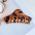 Close-up detail of the elegant tortoiseshell hair claw clip, minimalist design for buns. - Matte Coffee Leopard
