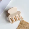 Gedetailleerde close-up van een minimalistische beige haarklem voor stijlvolle kapsels. - Effen Nude