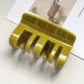 Detailed view of the elegant olive green hair claw clip, featuring a glossy minimalist design. - Mustard Yellow