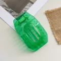 Close-up detail of a transparent green hollow flat hair claw clip, simple daily styling accessory. - Dark Green