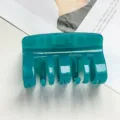 Close-up of deep teal transparent PC hair claw clip, showing glossy texture and detail. - Transparent Peacock Blue