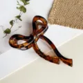 Detailaufnahme einer eleganten braunen Schleifen Haarklammer aus Kunstharz Haarschmuck. - 10cm / Glänzend Kaffee Leopard