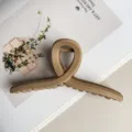 Nahaufnahme einer matten Beigen Kreuz Haarklammer, Premium dickes Design für elegante Frisuren. - Mattes Khaki