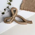 Detailansicht einer matten beigen Schleifen-Haarklammer, elegantes Accessoire zum Stylen. - 10cm / Mattes Khaki