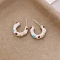Gros plan détaillé de boucles d'oreilles créoles en bambou irrégulier émaillé. - Clous en C en Émail de Bambou (11#) / Blanc-Bambou