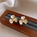 Vue de détail des élégantes boucles d'oreilles fleurs émaillées avec une perle centrale. - Boucles d'oreilles clous fleurs en émail dégradé (10#) / Or-Bleu