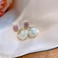 Gros plan détaillé du cube de cristal iridescent et des boucles d'oreilles en zircon rose. - Clous d'oreilles zircone cubique à tige en argent (15#) / Couleur AB-Rose