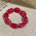 Detail view of a stylish hot pink marbled acrylic bead and gold spacer elastic bracelet. - Round Bead Splicing Elastic Bracelet / Rose Red