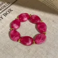 Close-up detail of hot pink marbled acrylic and gold metal beaded stretch bracelet. - Round Bead Splicing Elastic Bracelet / Rose Red