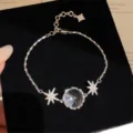 Gros plan sur le bracelet étoile argenté avec zircone cubique et pendentif globe. - Bracelet-Argent-Petit
