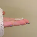 Detailed close-up of a French style hollow flower open ring with exquisite pearl accents. - Pearl Flower / Adjustable Open / Silver