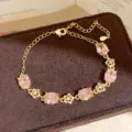 Close-up of elegant gold-plated bracelet with sparkling pink oval cubic zirconia stones. - Gold/Pink