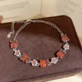 Gedetailleerd overzicht van de luxe zilveren armband met rode ovale zirkonia en stralende bloemen. - Zilver/Rood