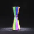 Gedetailleerd opname van een achthoekige roestvrijstalen cocktailjigger met regenboogafwerking. - Veelkleurig