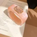 Close-up of pink marbled resin cuff bracelet featuring a large emerald-cut crystal in gold setting. - 2# Bangle - Pink