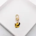 Close-up detail of the metal keychain pendant with bat and moon design, gold alloy. - Bat and Moon