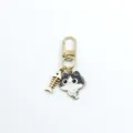 Close-up detail of cute black and white cat keychain with a fish skeleton pendant charm. - Black and White Cat Style (4)