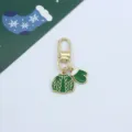 Detailed shot of Christmas metal keychain with green sweater and mitten enamel pendants. - Green Sweater and Gloves (2)