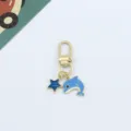 Detail view of cute blue dolphin and star metal keychain pendant, exquisite craft and glossy finish. - Dolphin