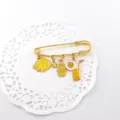 Detail view of the cute summer fruit series enamel brooch pin featuring lovely hanging charms. - Banana