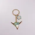 Close-up detail of the western bull skull keychain with blue floral enamel alloy pendant. - American Bull Style 3 (3)