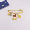 Detail shot of cute capybara enamel brooch, gold tone safety pin badge with lovely charms. - Capybara with Milk Bottle and Shooting Star Style