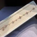 Close-up van gouden bloemenarmband met zirkoon, elegante detailweergave van luxe sieraden. - Armband / Goud-Roze