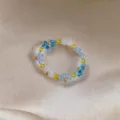 Detailed view of handmade crystal beaded floral jewelry, featuring delicate blue and yellow design. - Ring / Blue Green