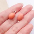 Nahaufnahme von pfirsichfarbenem Harz-Anhänger oval mit Metallöse für DIY-Schmuckherstellung - 3D Tier Ei (27567) / 1 Stück (15x8x8mm) / Orange