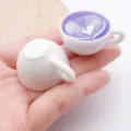 Miniature resin coffee cup charm with heart latte art, perfect for DIY jewelry and crafts. - Glowing Rainbow Light Latte Art Coffee Cup (24794)