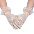 Detailaufnahme von beigen Vintage-Spitzenhandschuhen mit Schleife und zarten Rüschen im Sommer. - Einheitsgröße / Beige