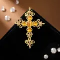 Detailaufnahme der Vintage Goldlegierung Kreuz Brosche mit bernsteinfarbenen Katzenaugen und Strass. - Gold