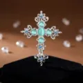 Elegante Kreuz-Brosche aus Legierung mit türkisen Katzenaugen-Steinen und funkelnden Strasssteinen. - Silber